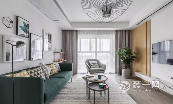 入门玄关的设计,下面青岛装修公司小编来带您看看客厅的设计。 客厅地面通铺木色地板,简约的空间中,搭配跳跃色的家具,走线功能的吊顶装一盏创意镂空吊灯,丰富顶面空间。 简单的素白墙面,加入了木饰面与大理石的修饰,让空间增添质感,且让墙面不显单调。 餐厅地面通铺木地板,延续着客厅的素白墙面,一组黑色入墙置物架,简单实用的修饰了餐厅的背景墙,实木餐桌结合绿色餐椅与餐凳的搭配,清爽的布置出就餐区。